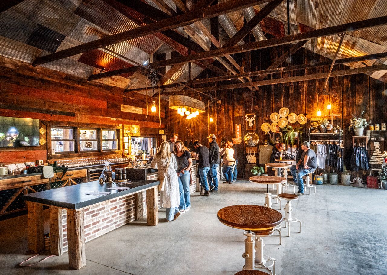 Inside the Marshall Stuart Fine Wines tasting room, with guests at the bar under reclaimed-wood beams